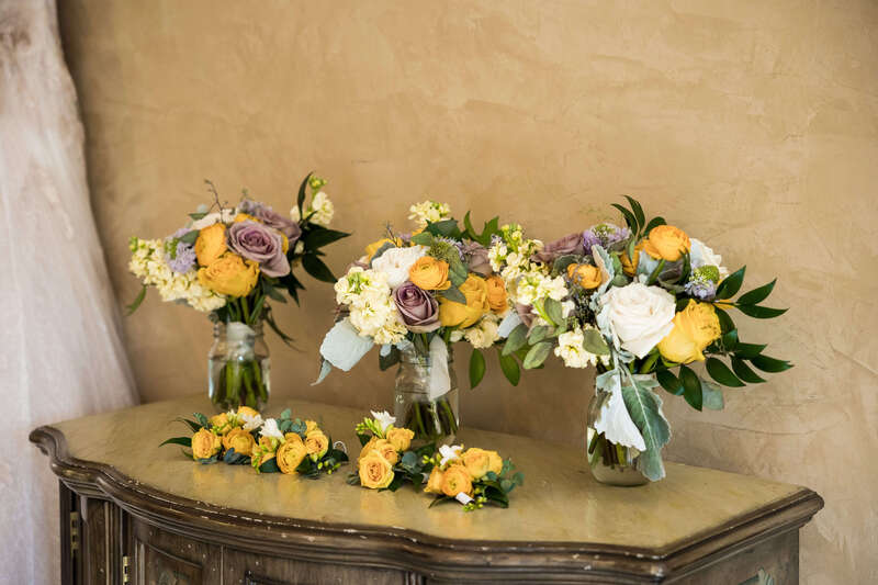 Bridal bouquets filled with yellow and lavender roses and white hydrangeas by Earth Tones Floral