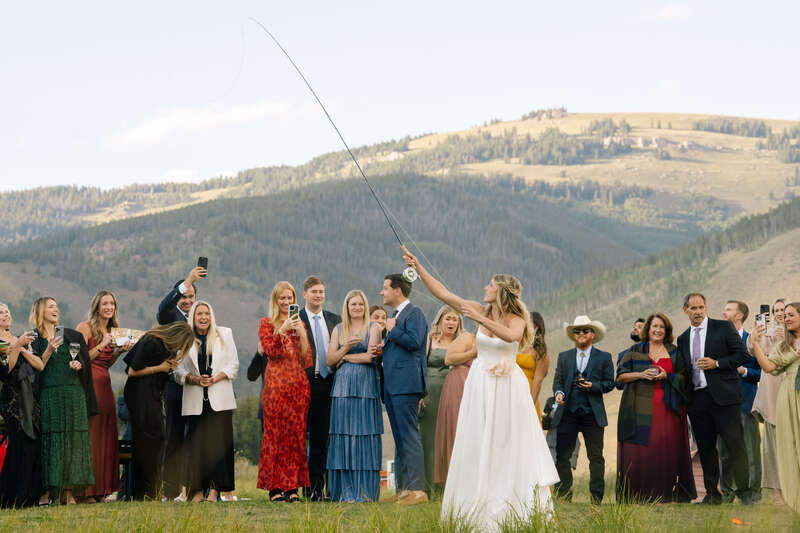 Wedding guests fly fishing at a mountain wedding in Colorado