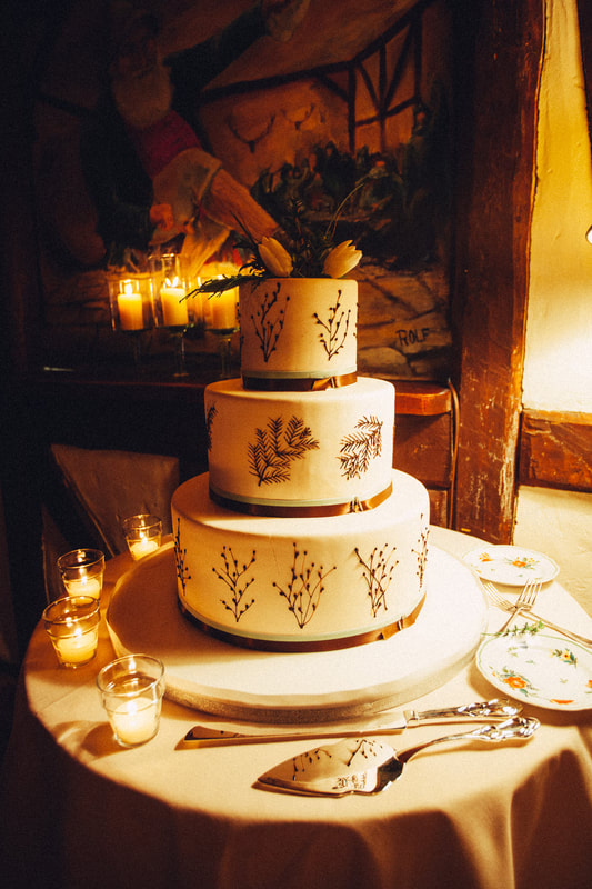 3 tiered white iced wedding cake with brown twig designs