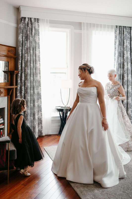 Bride putting on her Justin Alexander wedding gown at the Oxford Hotel