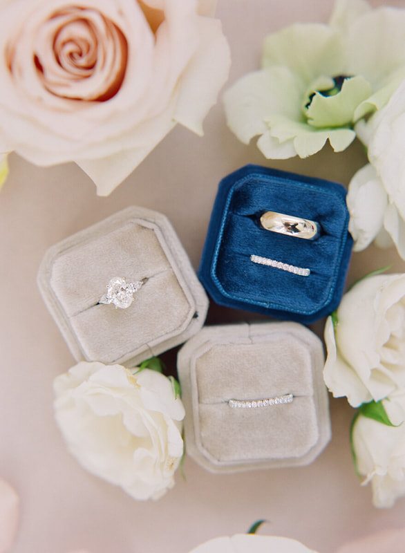 Wedding ring flat lay with velvet ring boxes and flowers