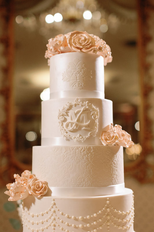 Tiered wedding crest cake with blush icing roses at The Broadmoor