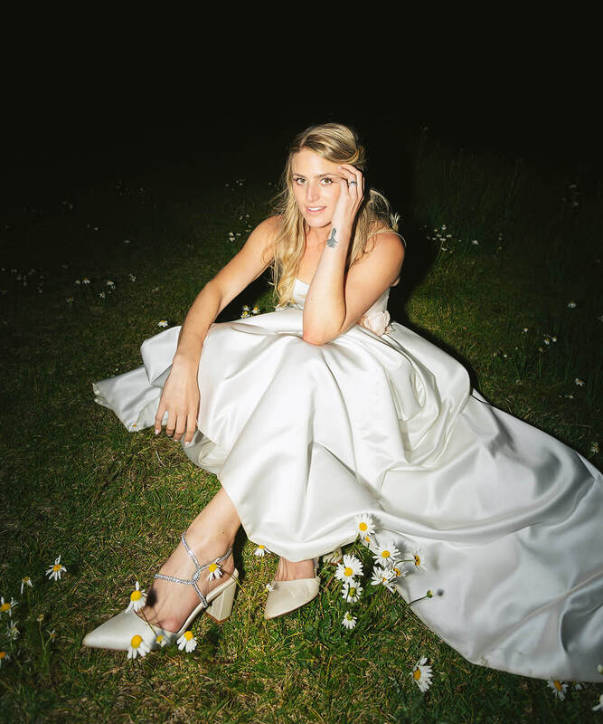 Bride sitting in a flower meadow at night