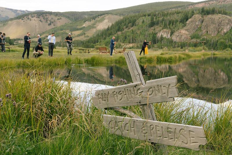 Wedding guests fly fishing at a mountain wedding in Colorado