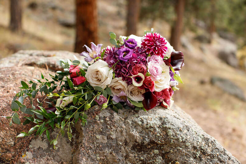 Cascading bridal bouquet in burgundy and plum by The Perfect Petal.