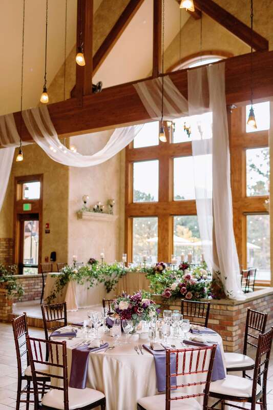 Indoor wedding reception with purple flowers at Della Terra Mountain Chateau