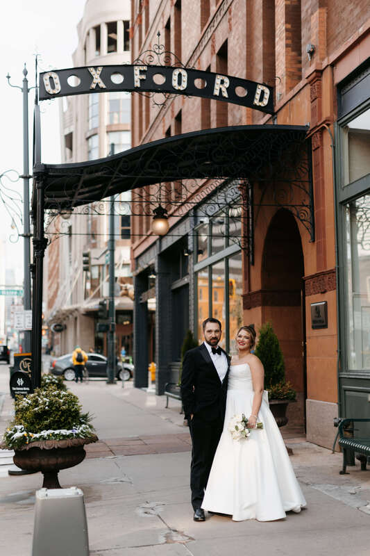 Bride and groom posing outside The Oxford Hotel in Denver, CO