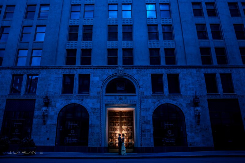 downtown denver wedding couple in front of historical brick building and up lit doors