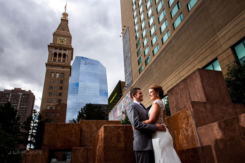 downtown denver bride and groom in front of downtown skyscrapers and the Clocktower horizon