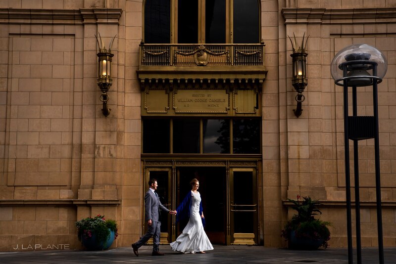 downtown denver wedding couple walking in front of the historical wedding venue at daniel fisher tower 