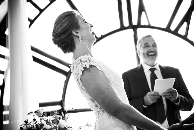 black and white photo of bride laughing during the wedding ceremony