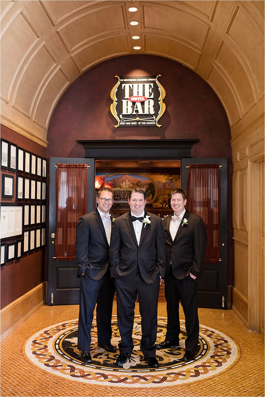 Groom and groomsmen in front of the doors of The Bar at The Broadmoor