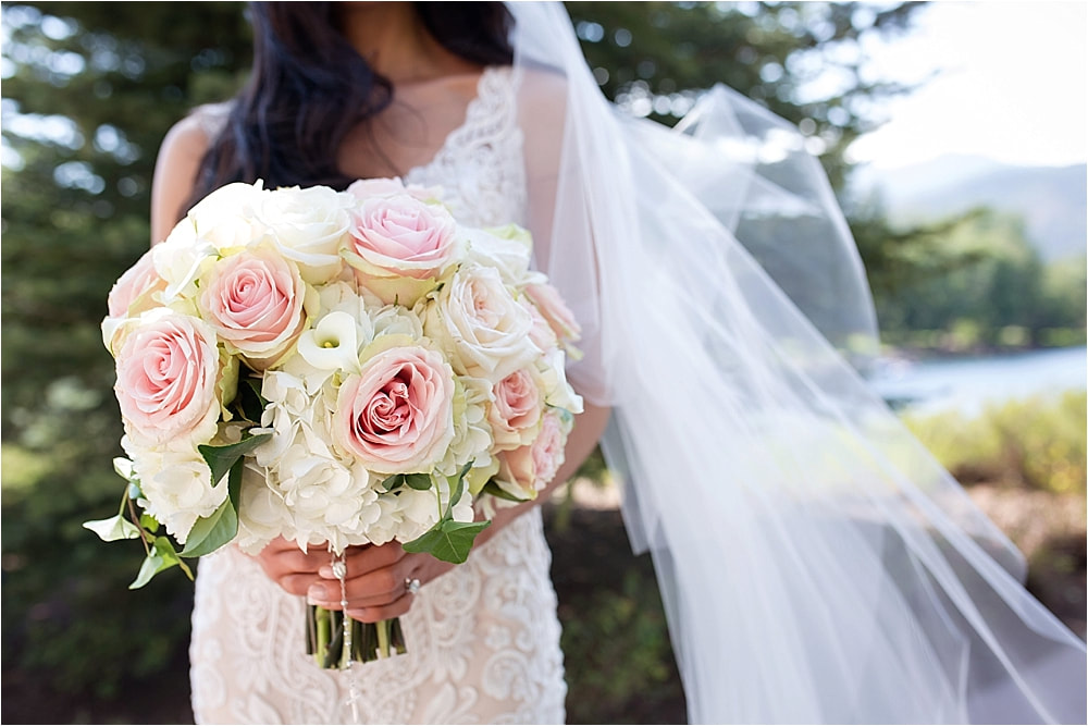 Bride holding a wedding bouquet filled with blush roses and white hydrangeas