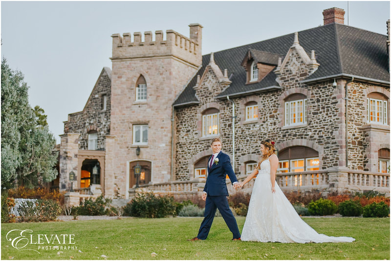 bride and groom strolling in front of Highlands Ranch Mansion