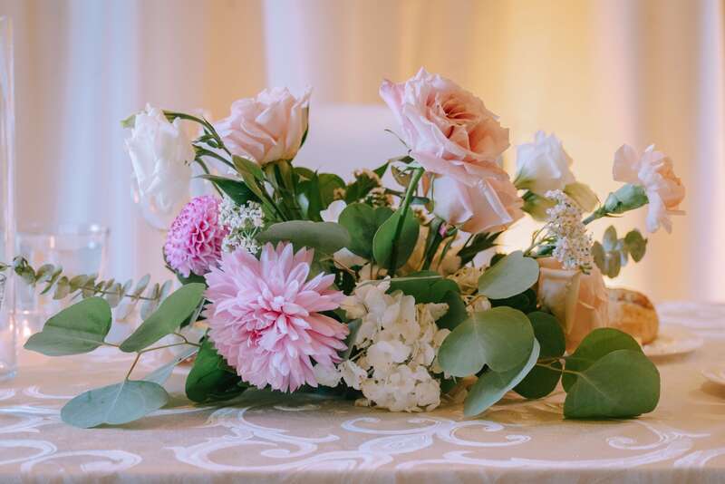 Floral centerpiece with blush roses and pink peonies by Newberry Brothers