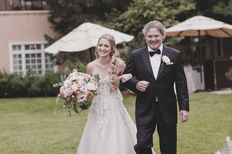 The Bride and her father smiling as they walk down the aisle