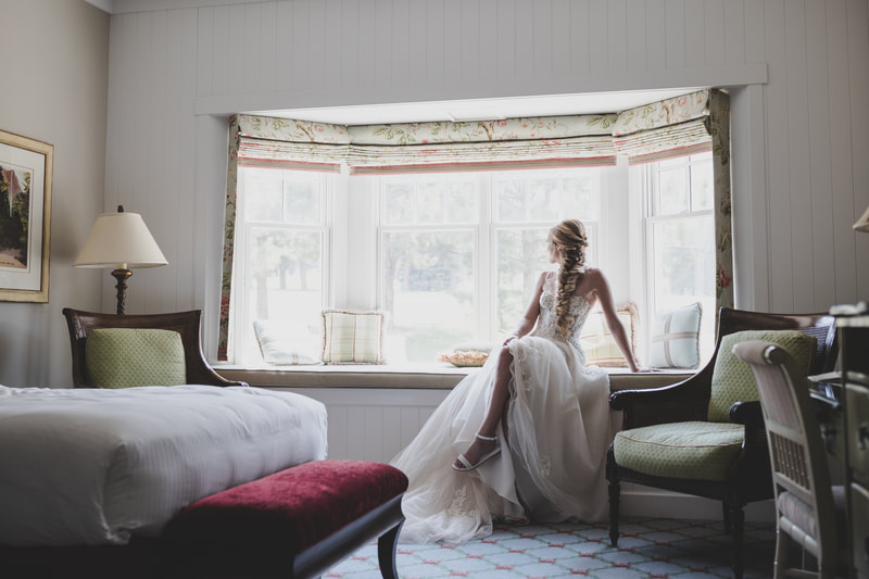 Bride in wedding dress sitting in the bay window and spotlighting bridal strappy sandals 