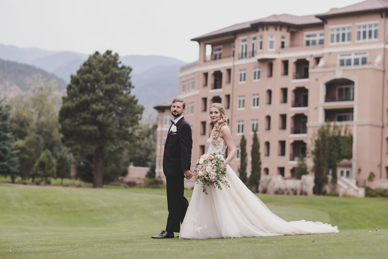 Bride and Groom with a backdrop of The Broadmoor and Colorado Springs Mountains