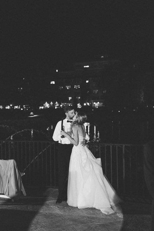 black and white photo of bride and groom kissing outside at the end of the evening
