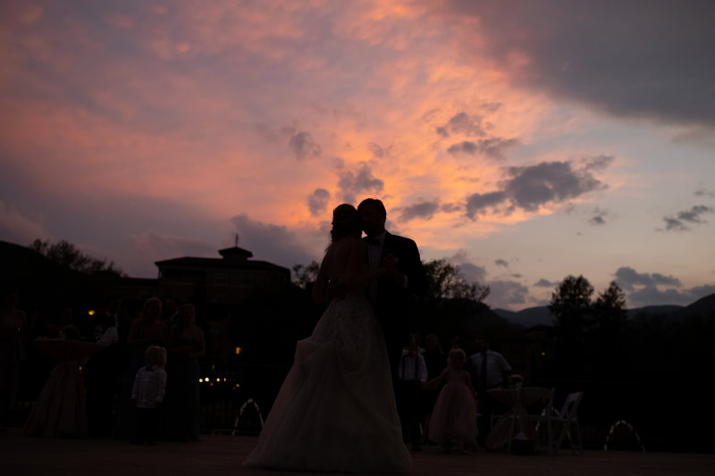bride and groom dancing with sunset in the background