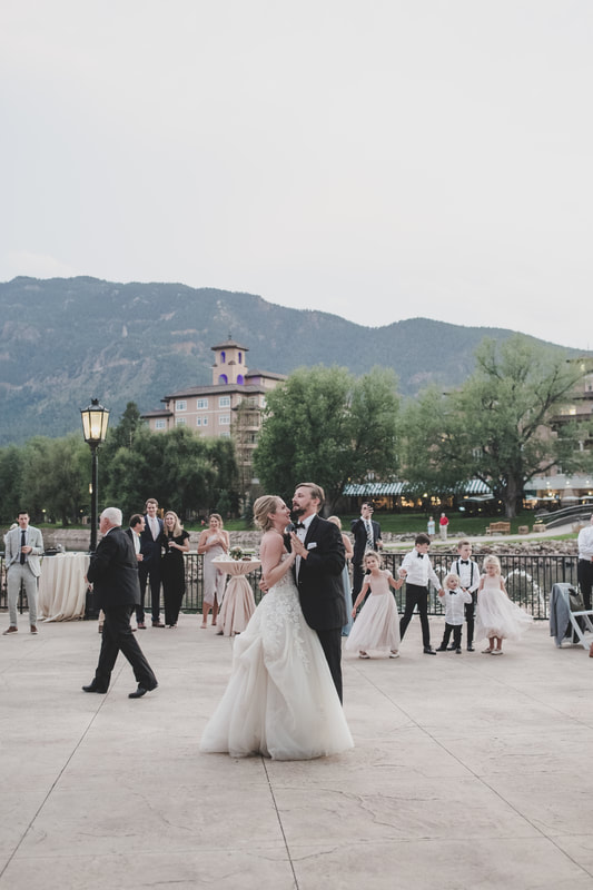Bride and groom dancing outside while guests watch