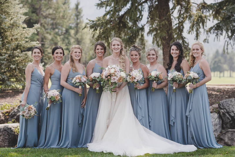 Brides standing her 8 bridesmaids in their blue bridesmaid dresses 
