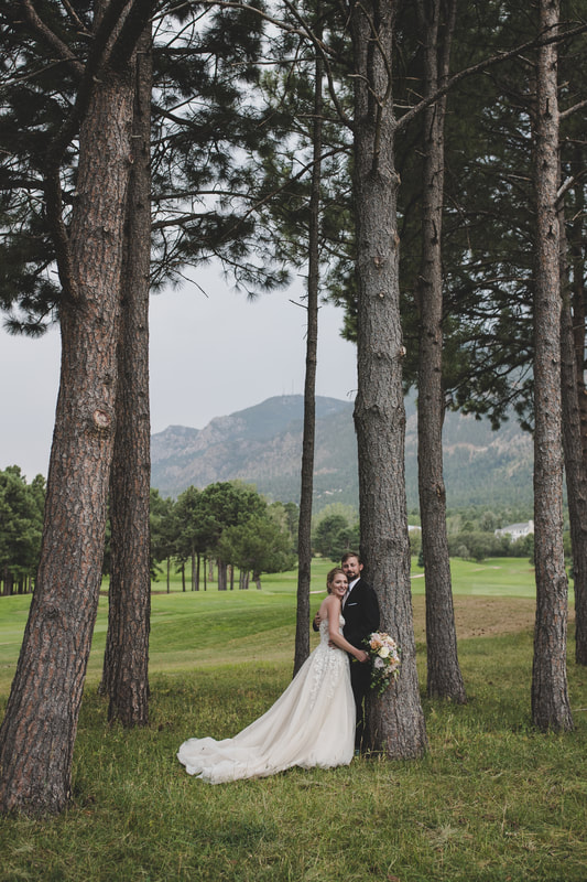 Bride and groom amongst the trees and the mountains in the background