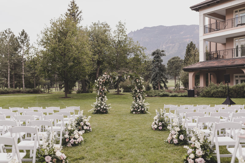 Outdoor wedding ceremony with floral wedding altar and guest seating with mountain views