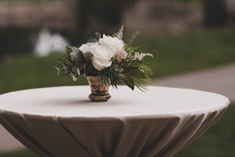 small cocktail table centerpiece with white roses and greenery