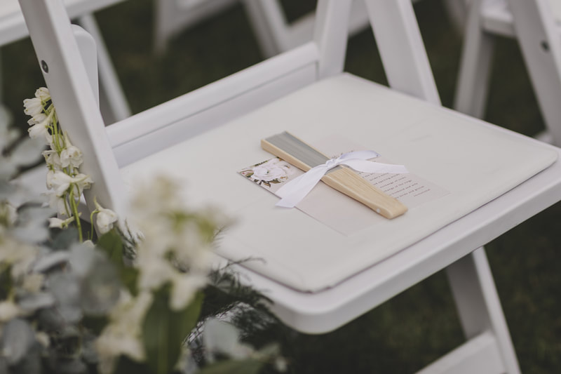 Wedding guest seat with wooden fan and printed wedding program